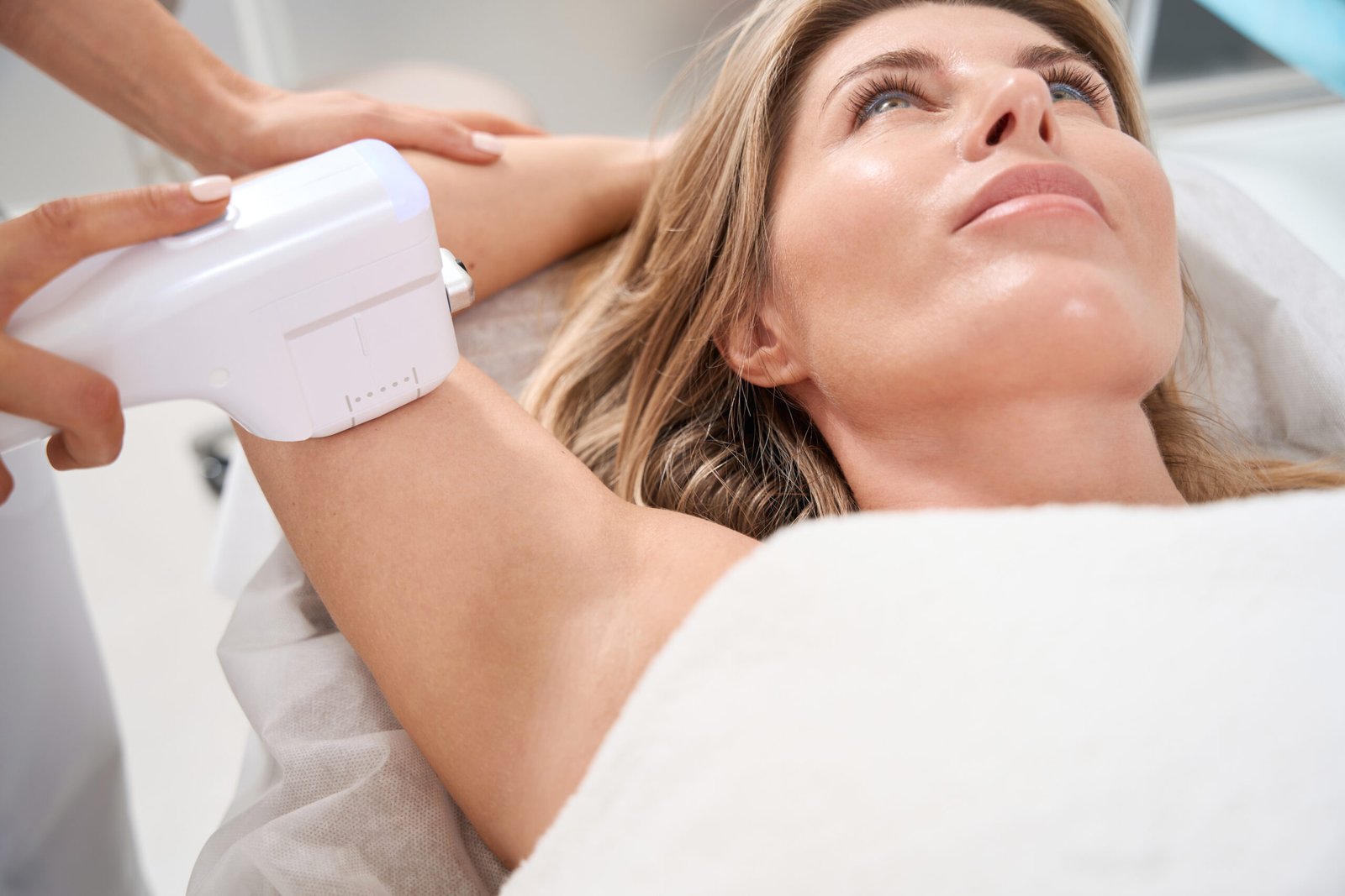 Woman on a smas lifting procedure in an aesthetic medicine clinic, a specialist uses a special apparatus